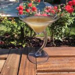 homemade daiquiri is coupé glass on a table by the rose garden